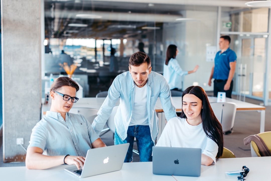 Small agency team working together around laptops