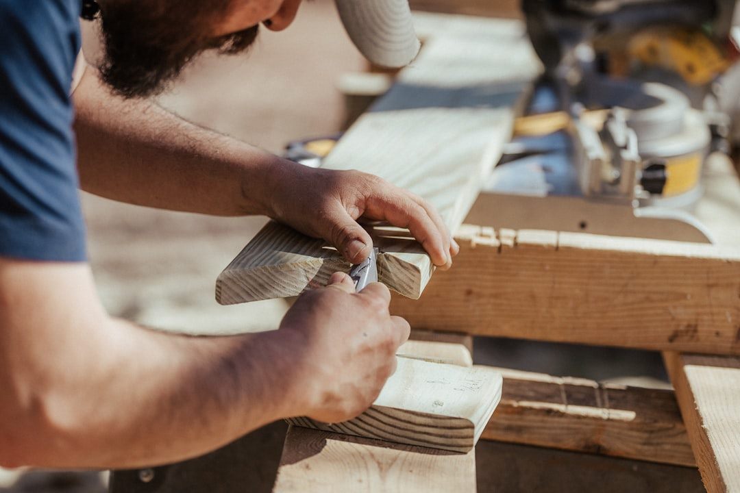Carpenter marking and cutting timber for first-fix carpentry on a building job
