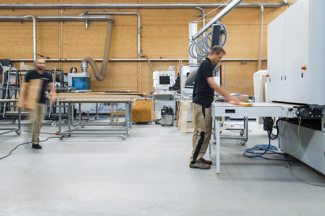 Two joiners at work in a fitted-out carpentry workshop, machining timber at the bench