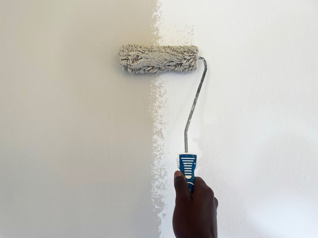 Decorator rolling a first coat onto a prepared wall