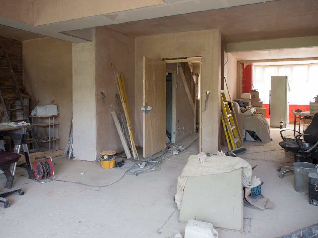 House interior mid-refurbishment with fresh plaster, ladders and dust sheets